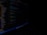 Close-up of hands typing code on a laptop keyboard in a dark room.