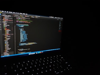 Modern laptop screen displaying code with a dark theme and blue-purple gradient.