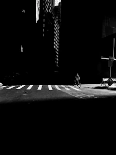 High-contrast image of a cyclist racing through a city street at dusk