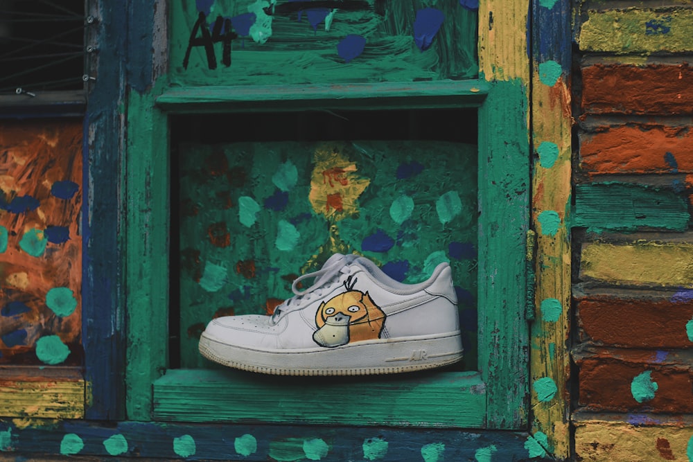 white and brown low top sneakers on blue wooden window