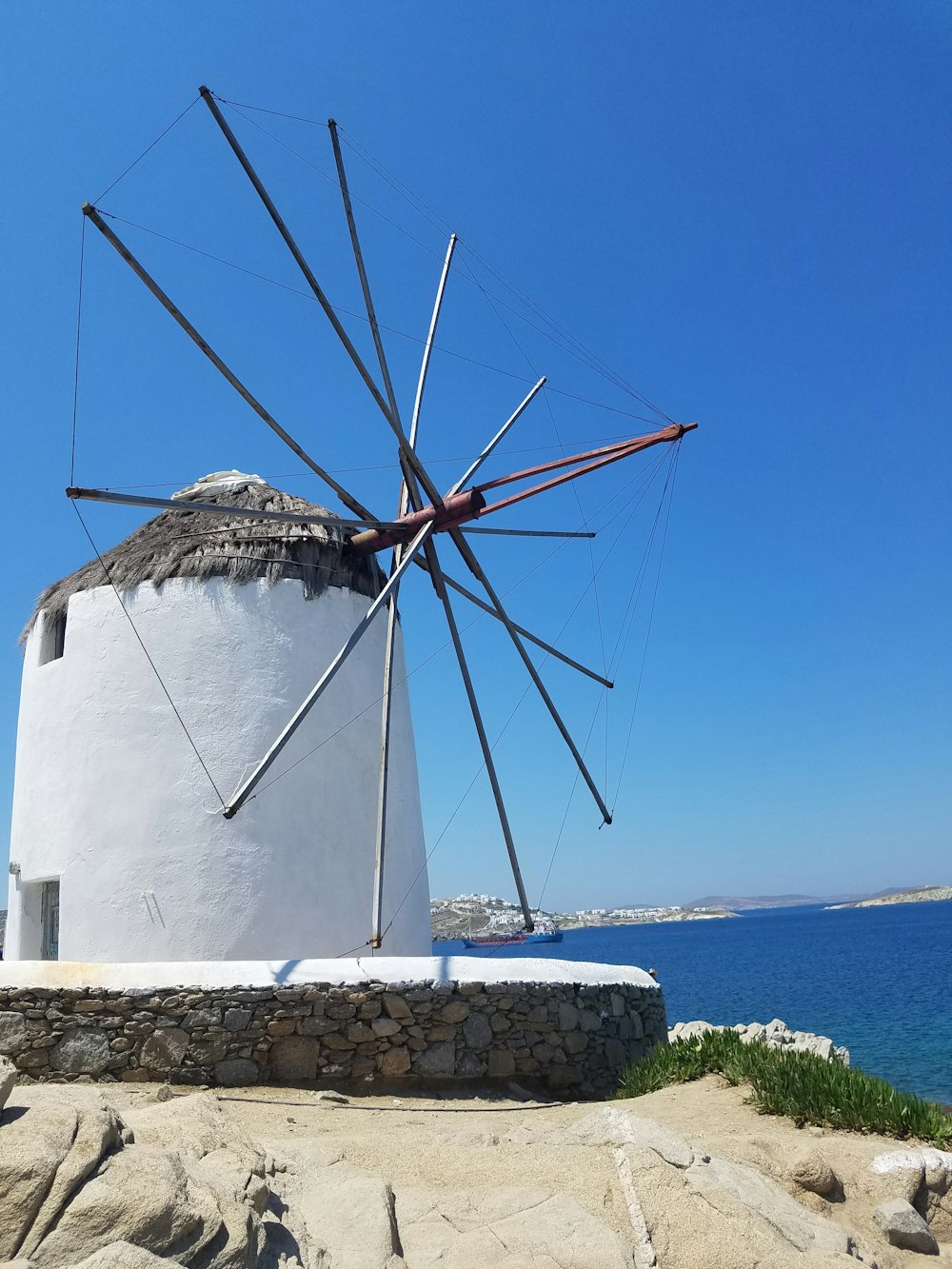 white and brown windmill near body of water during daytime