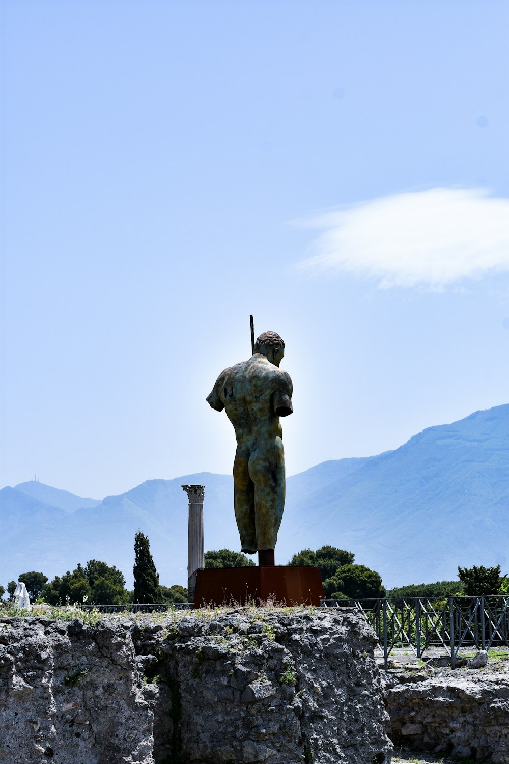 Estatua del hombre en la cima de la montaña durante el día