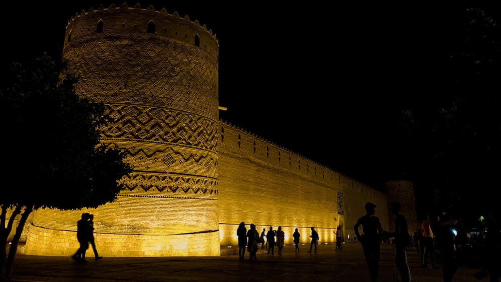 people walking near brown concrete building during nighttime