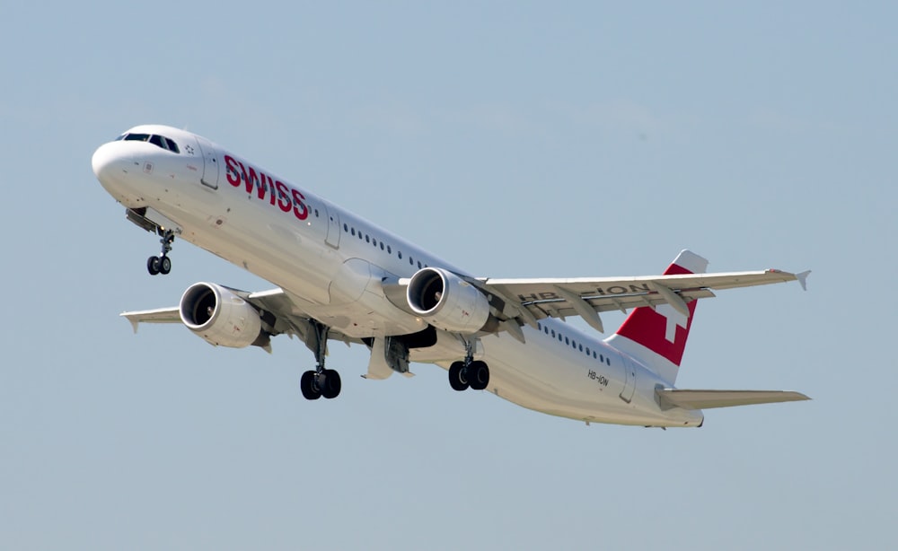 white and red passenger plane flying during daytime