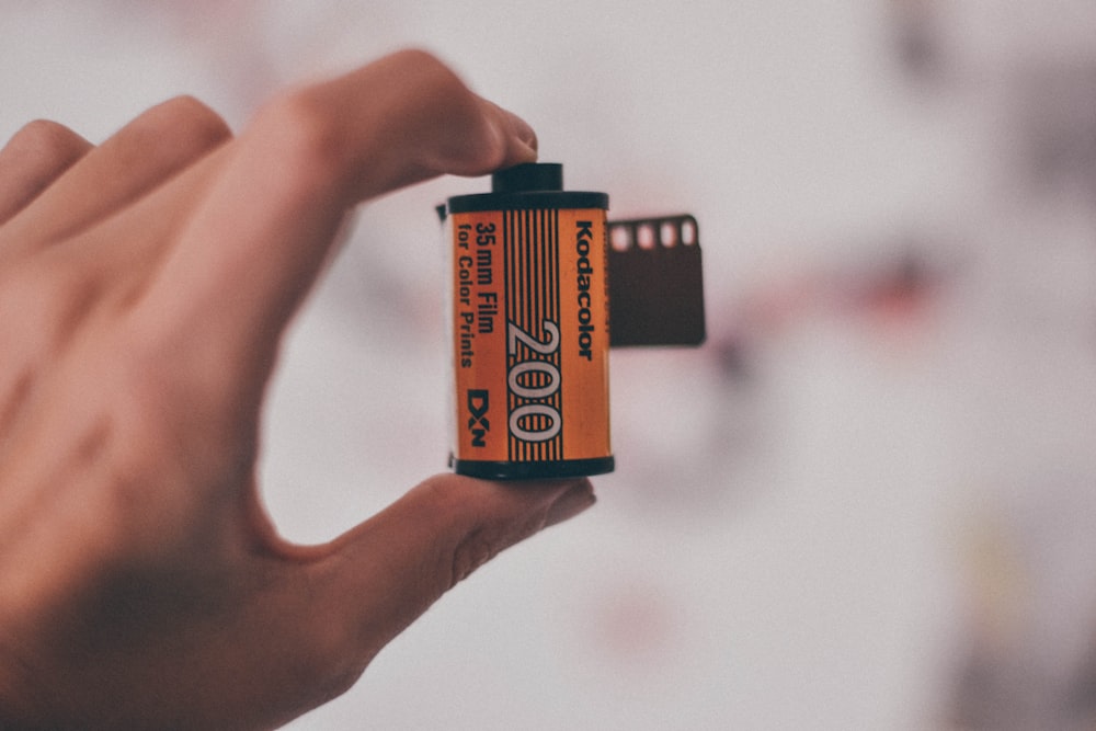 person holding orange and black box