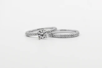 silver diamond studded ring on white surface