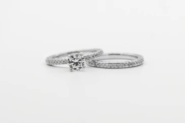 silver diamond studded ring on white surface