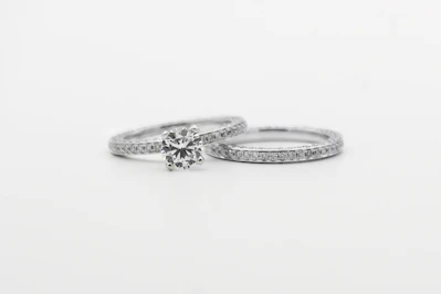 silver diamond studded ring on white surface