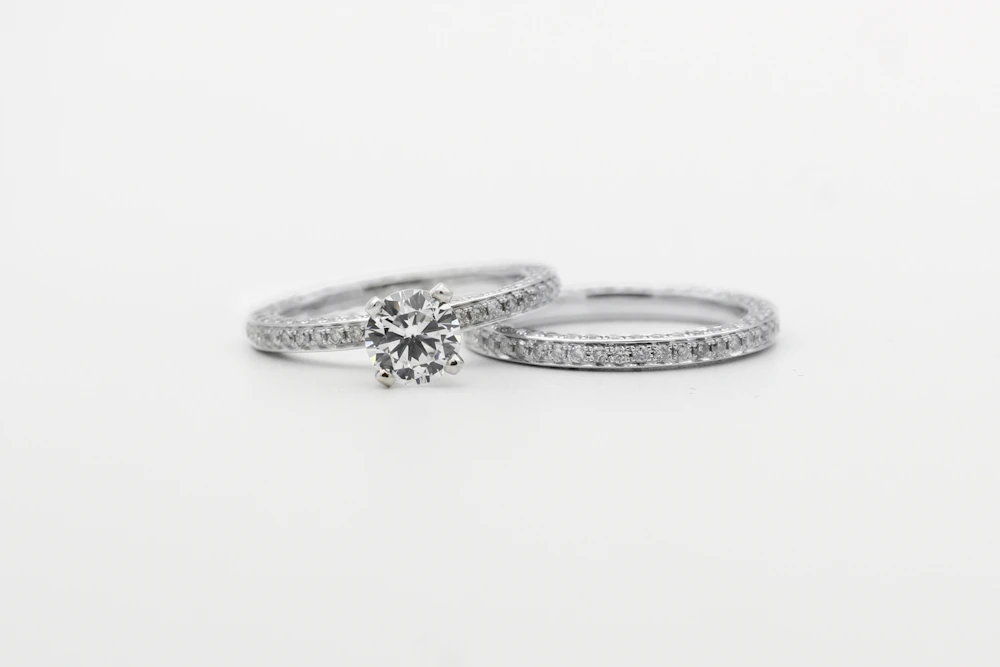 Two diamond-set silver rings on a white surface
