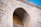 A detailed stone arch with intricate Arabic calligraphy in gold is featured. The arch is adorned with carvings of a crescent moon and star, symbols commonly associated with Islam. The building is constructed from light-colored stone with ornate details, reflecting traditional Islamic architectural elements.