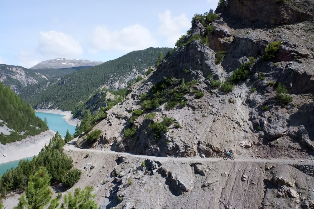 green and gray mountain beside body of water during daytime