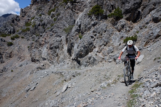 man in black and white shirt riding mountain bike on rocky mountain during daytime in Bormio Italy