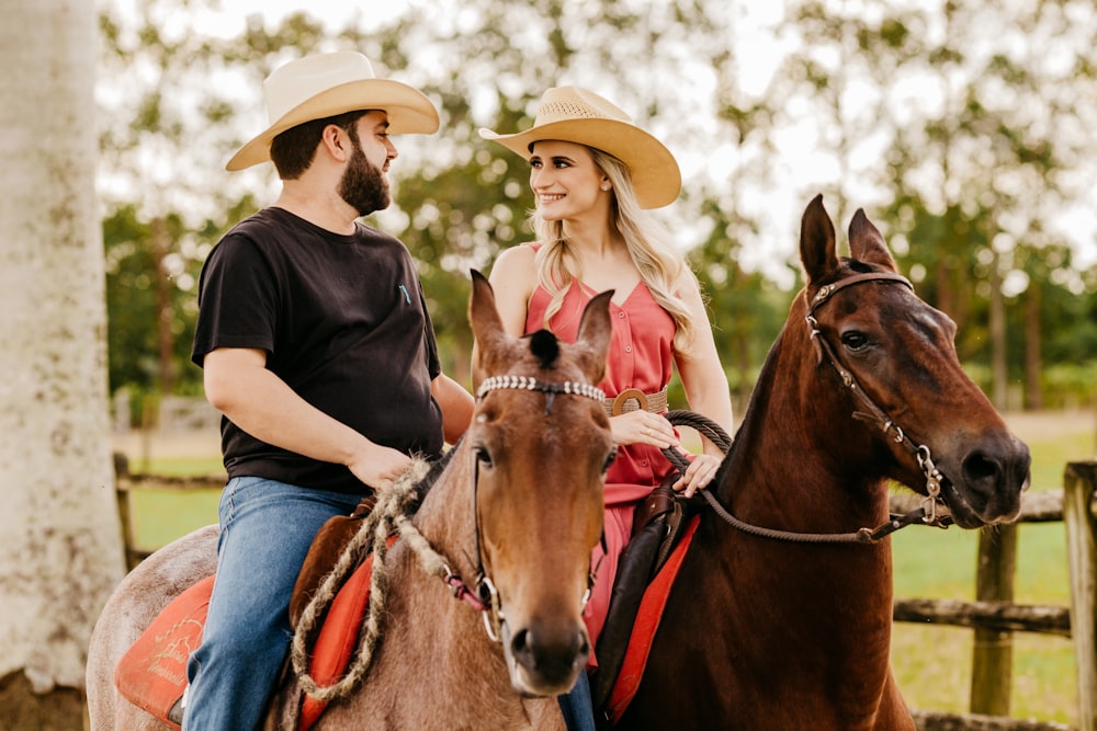 woman in black shirt and blue denim jeans wearing brown cowboy hat riding brown horse during