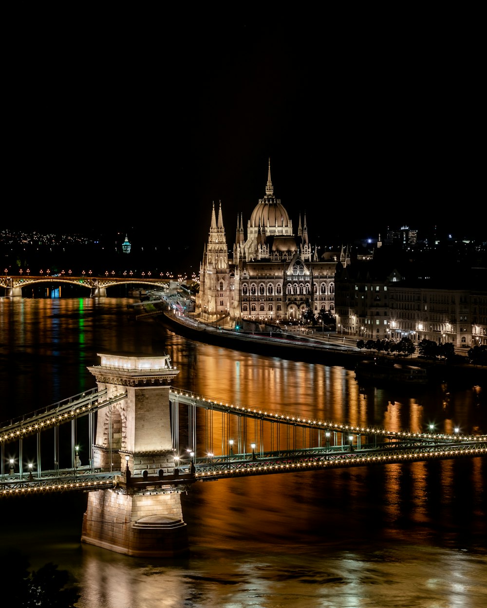 夜間の川に架かる茶色の橋