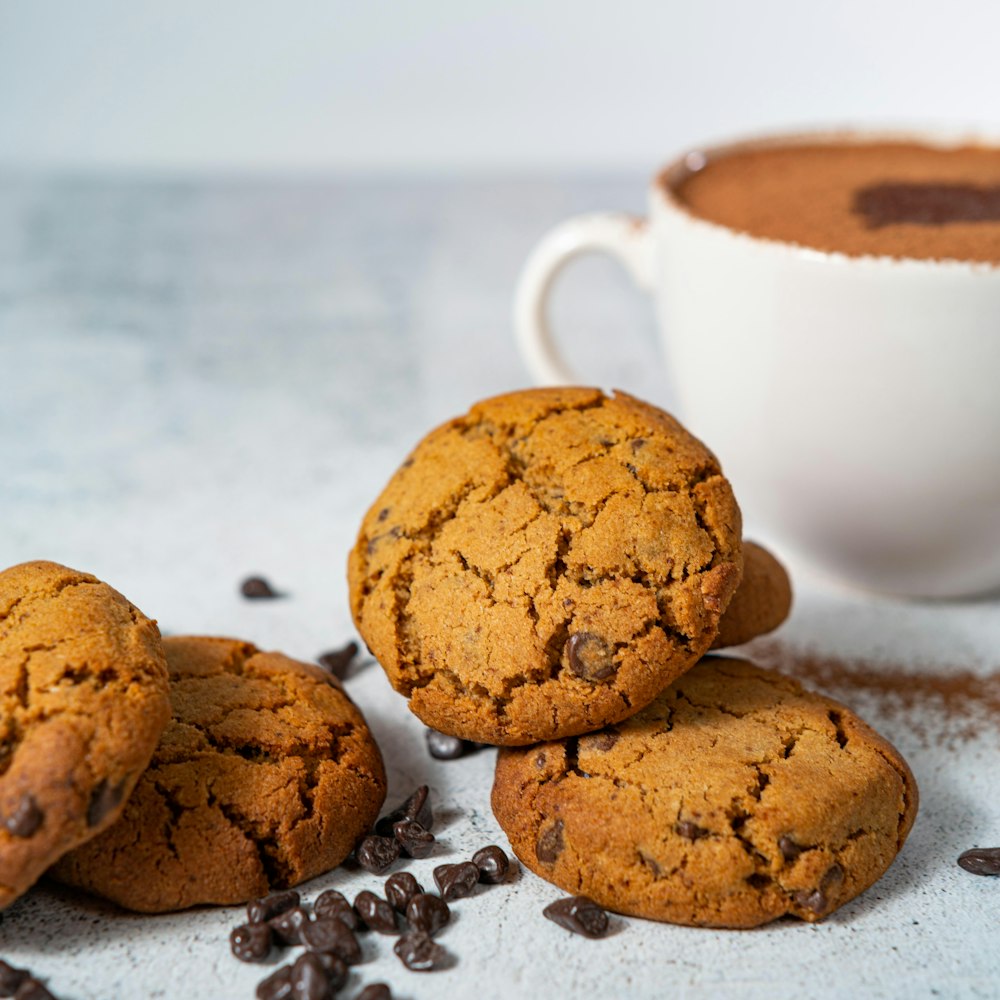 brown cookies beside white ceramic cup