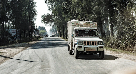 A delivery truck driving through a scenic neighborhood on a sunny day.