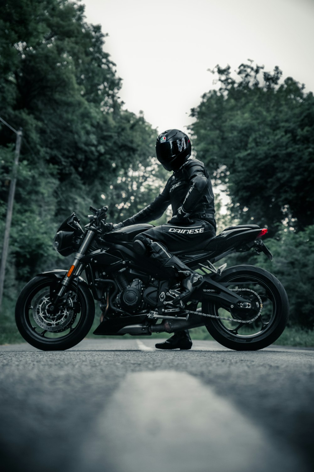Mann in schwarzem Motorradhelm fährt tagsüber Motorrad