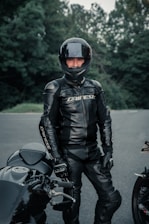 man in black leather jacket and helmet riding motorcycle