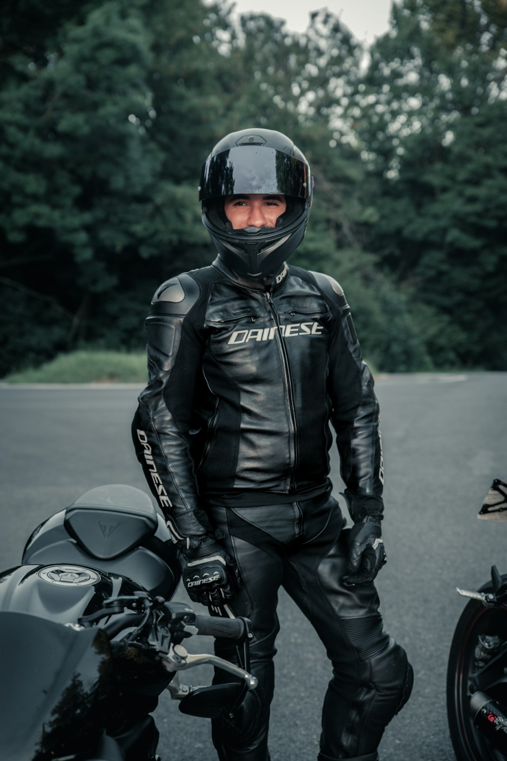 man in black leather jacket and helmet riding motorcycle