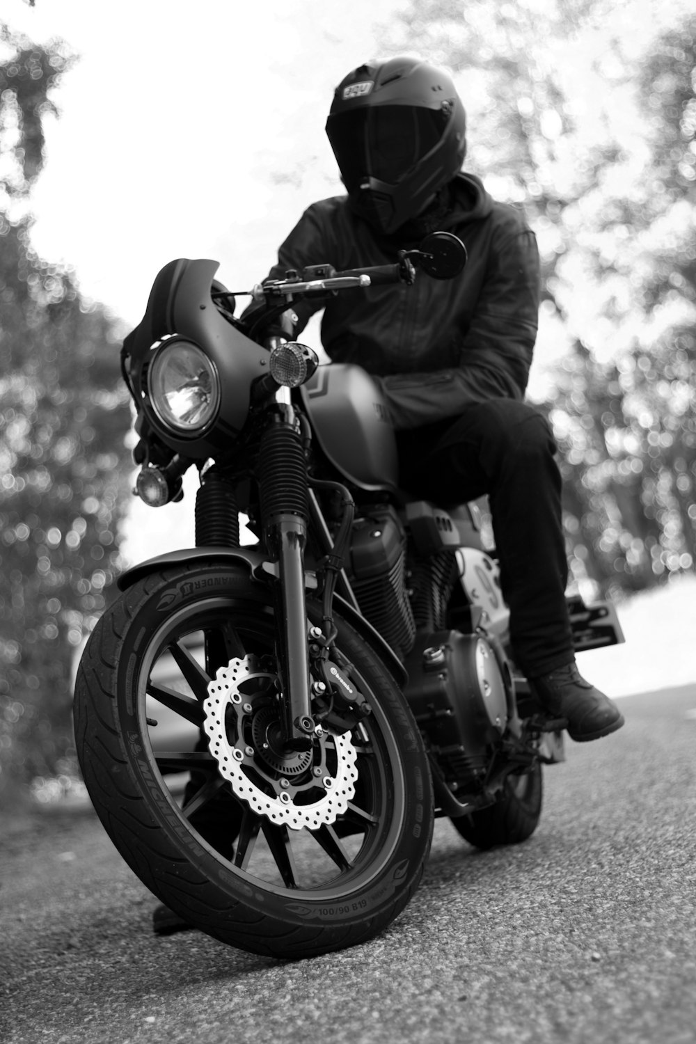 grayscale photo of man riding motorcycle