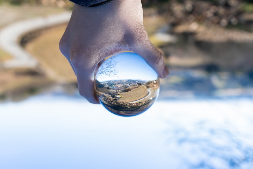 person holding clear glass ball