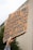 A hand is holding up a cardboard protest sign with bold, handwritten lettering. The sign has a message about neutrality and oppression, emphasizing a strong stance on social justice issues.