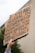A hand is holding up a cardboard protest sign with bold, handwritten lettering. The sign has a message about neutrality and oppression, emphasizing a strong stance on social justice issues.
