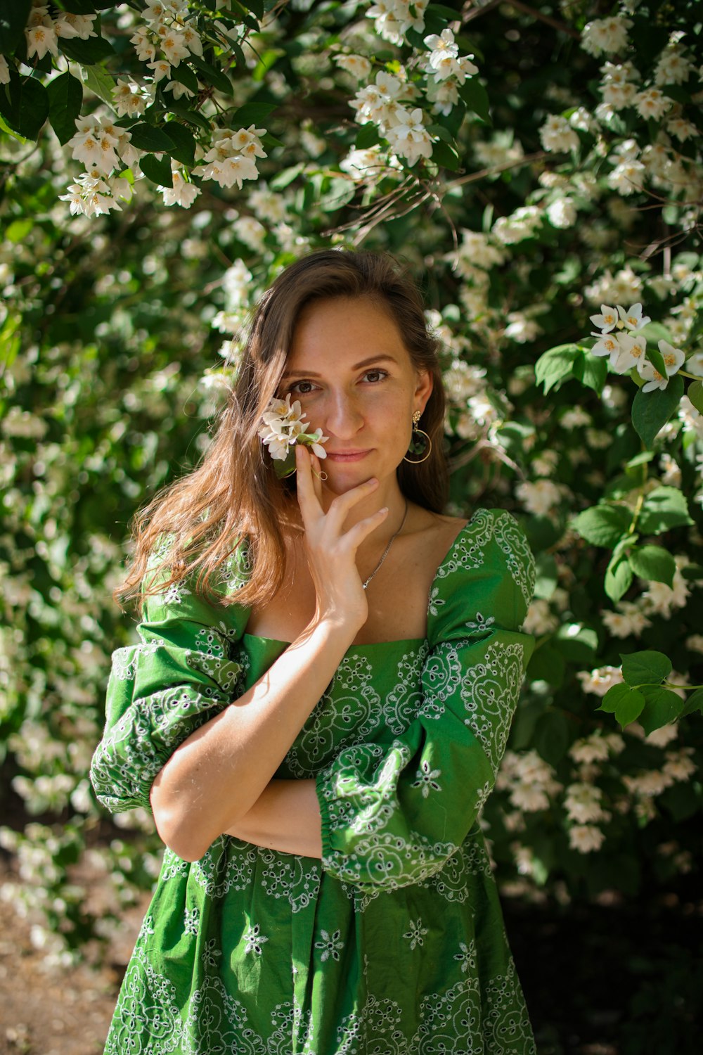 woman in green and white floral dress sitting on green grass during daytime