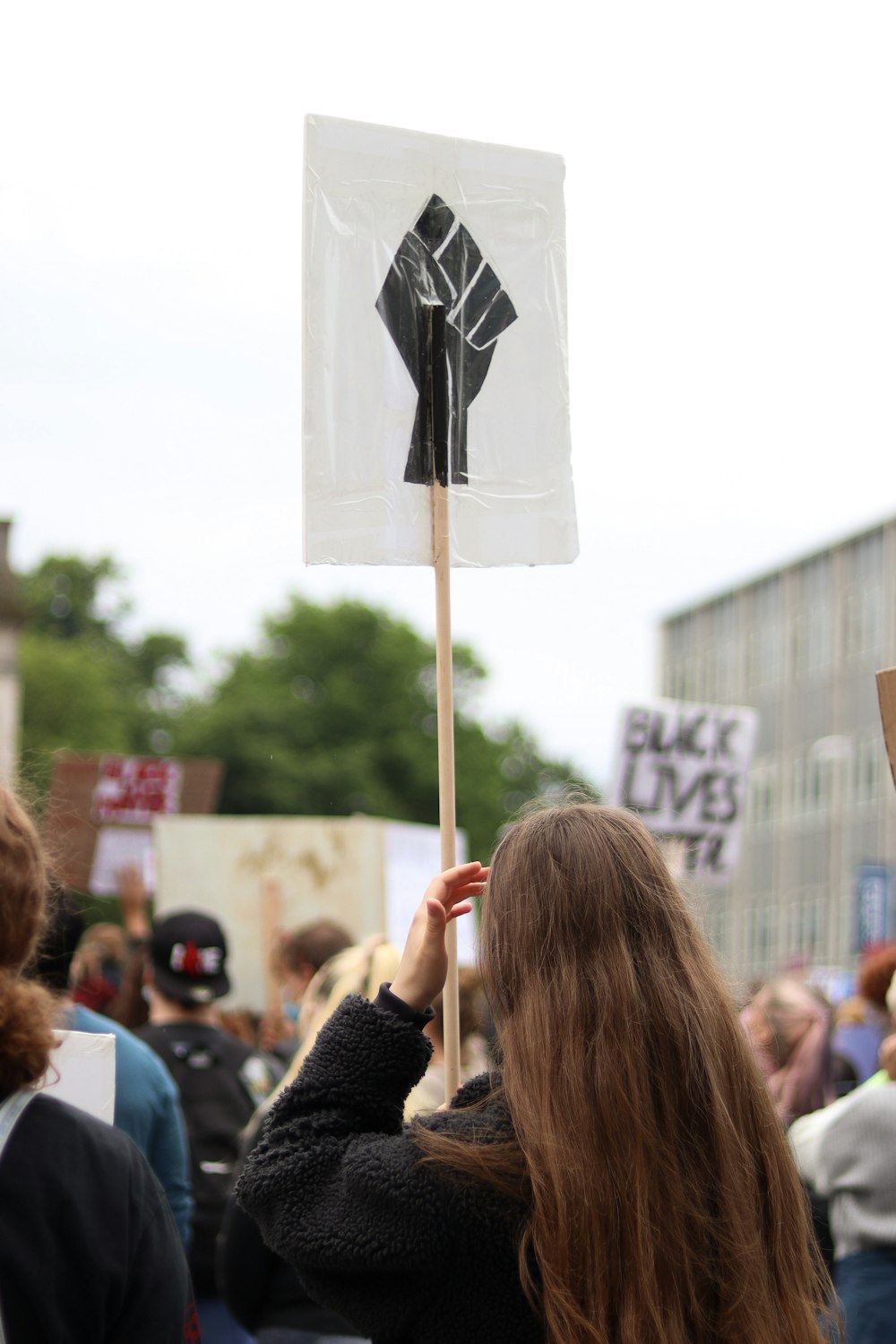 woman holding black and white banner