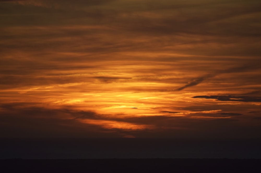orange und graue Wolken bei Sonnenuntergang