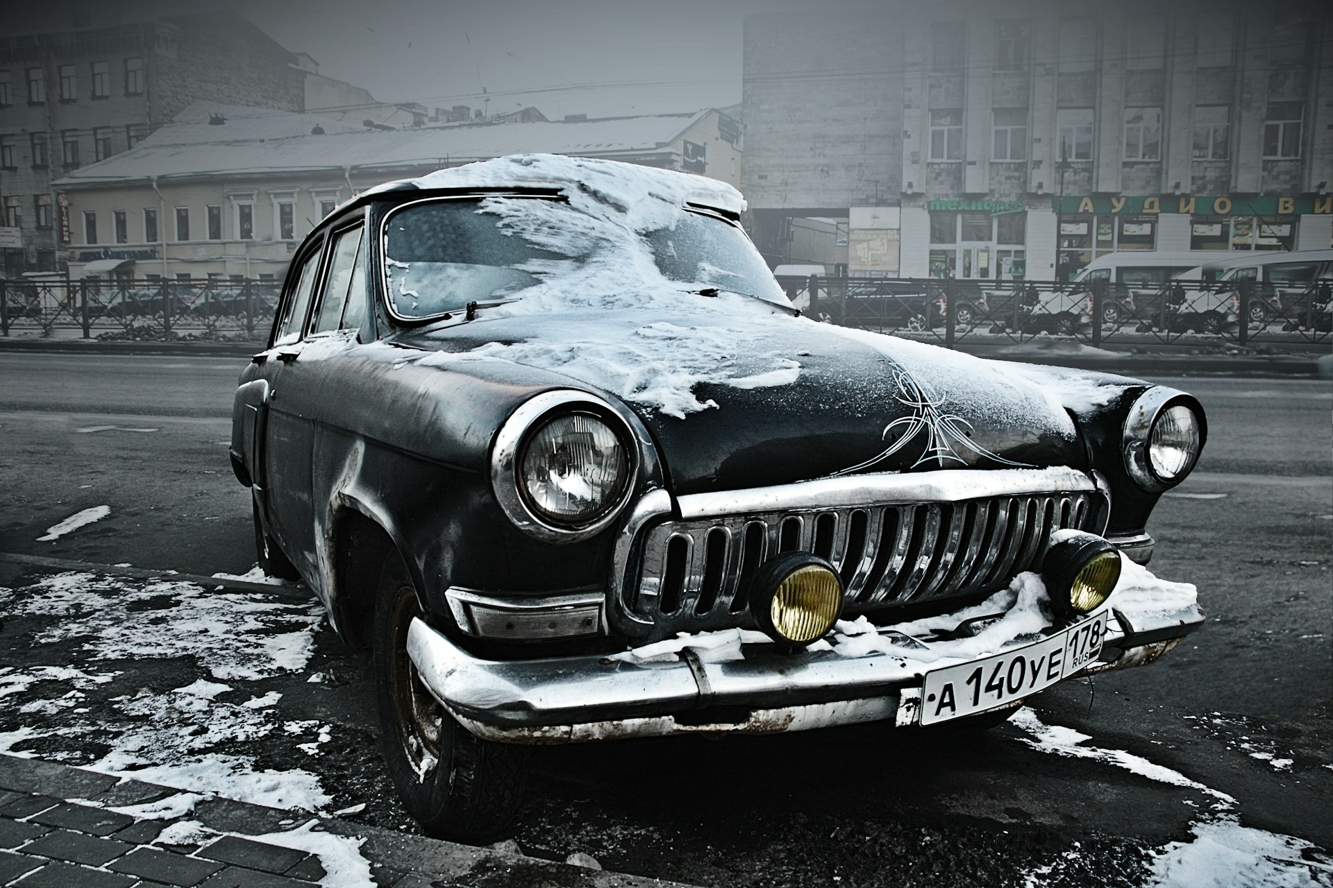 grey classic car parked near building