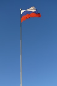 a flag is flying high in the blue sky