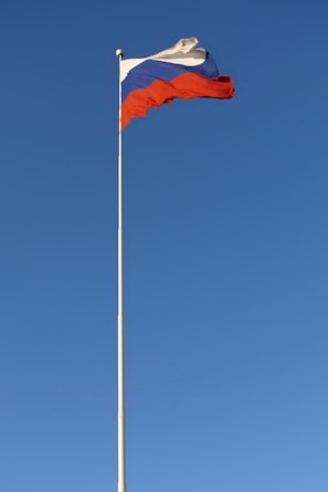 a flag is flying high in the blue sky