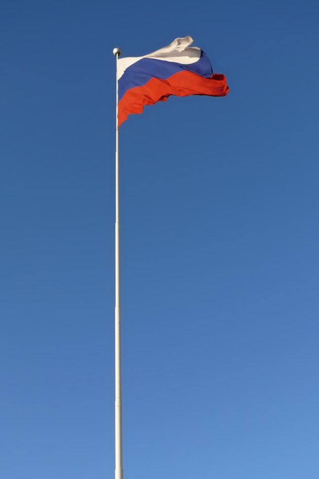 a flag is flying high in the blue sky
