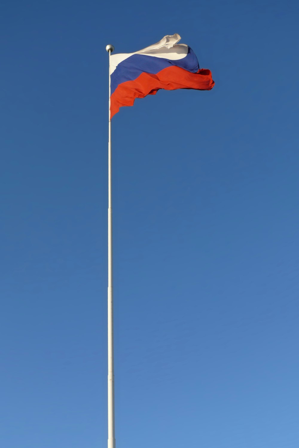 a flag is flying high in the blue sky
