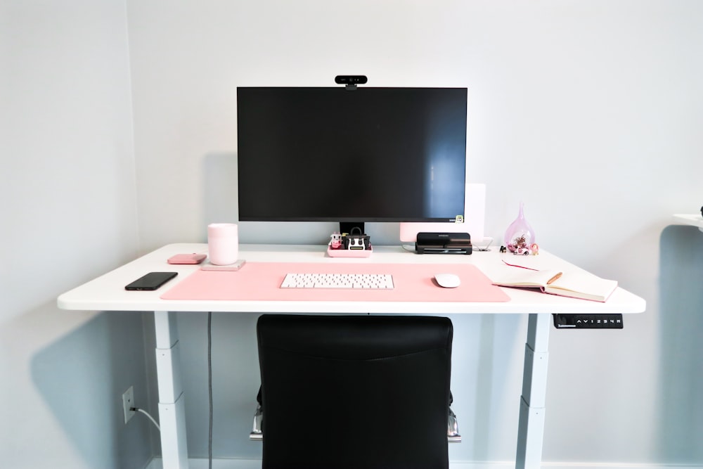 black flat screen tv on white and pink wooden table