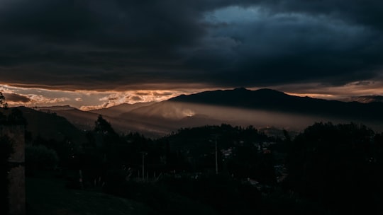 silhouette of trees and mountains during sunset in Cuenca Ecuador