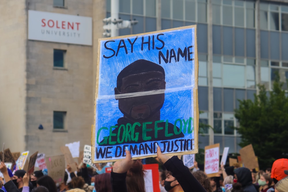 man holding blue and white signage