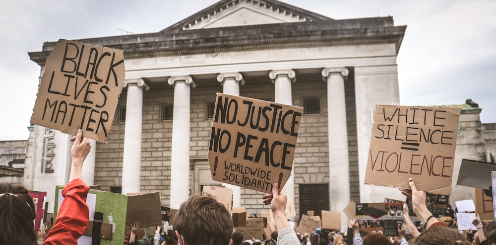 a group of people holding signs in front of a building