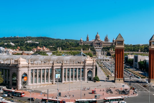 cars parked in front of brown concrete building during daytime in Museu Nacional d'Art de Catalunya Spain