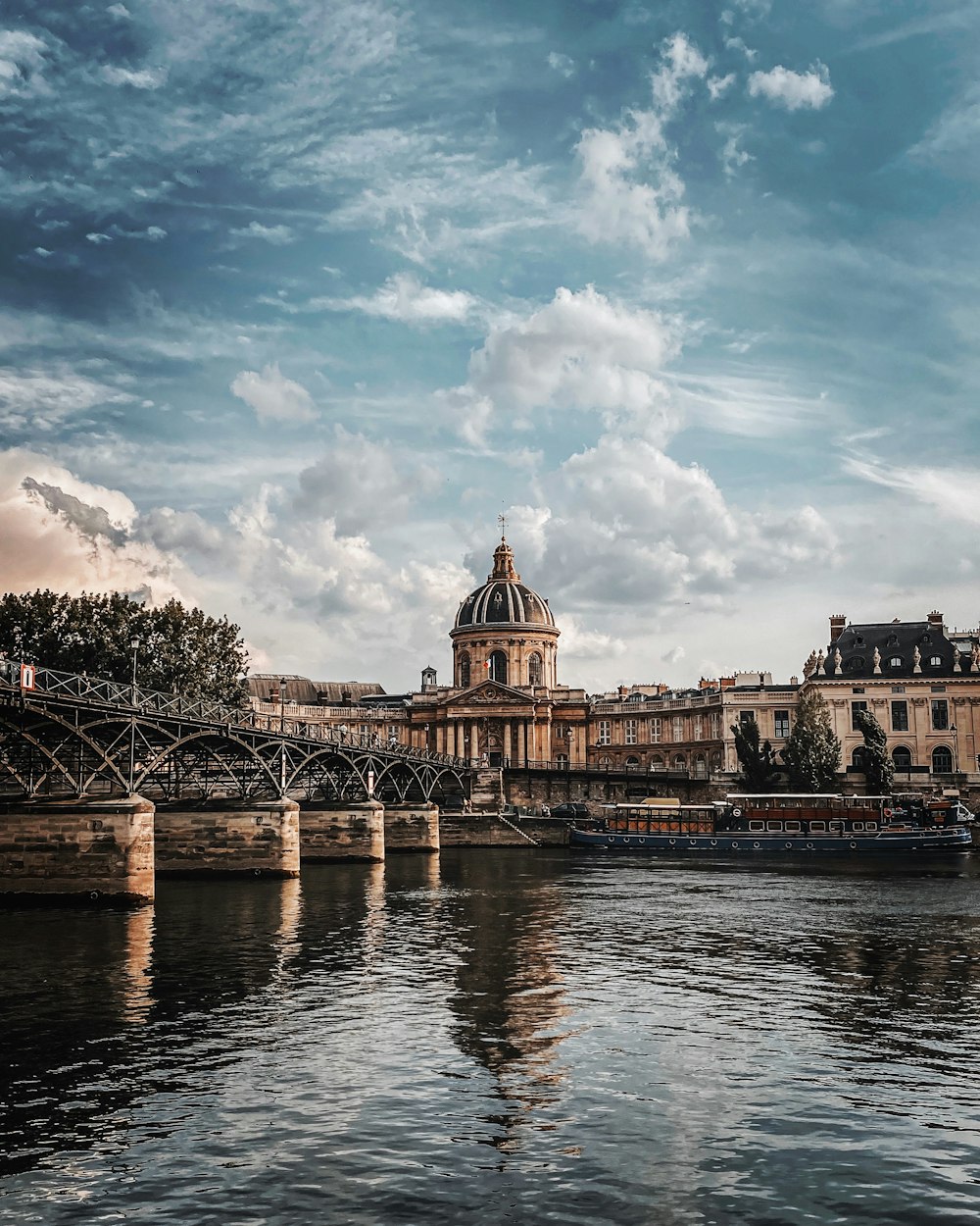 brown concrete building near bridge under cloudy sky during daytime