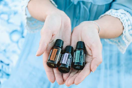 Close-up of hands holding healing herbs and essential oils.
