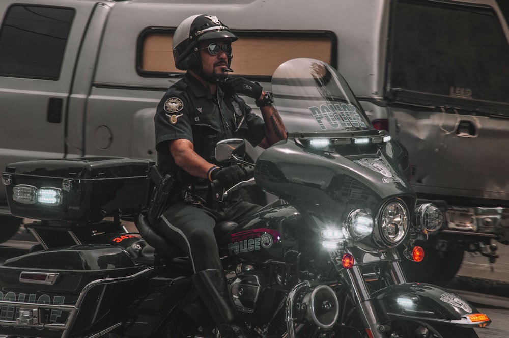 man in black jacket and helmet sitting on black motorcycle