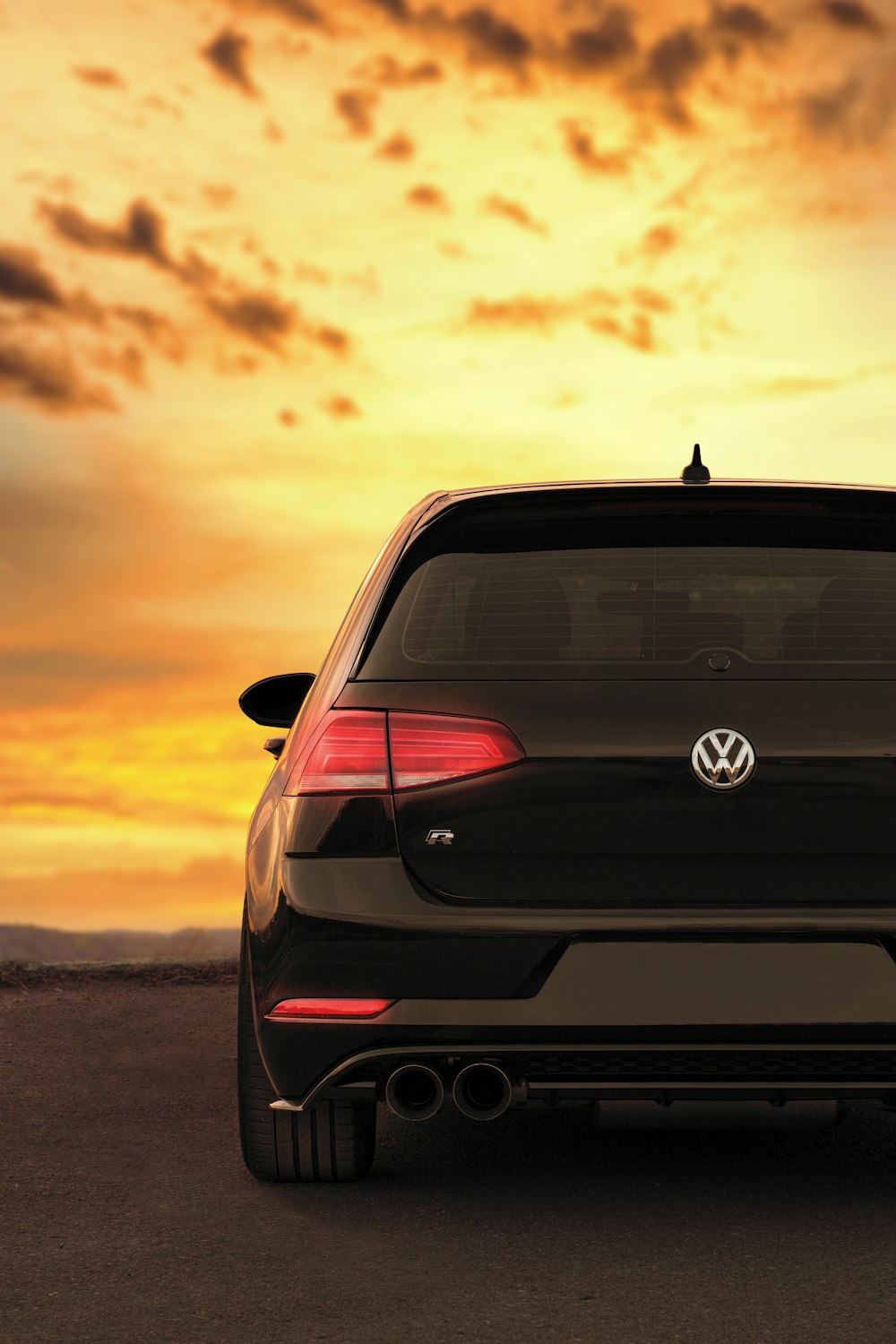 Mercedes Benz Classe C noire sur une route asphaltée grise au coucher du soleil