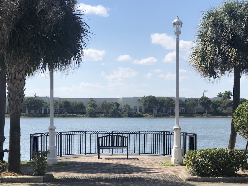 white metal lamp post near body of water during daytime