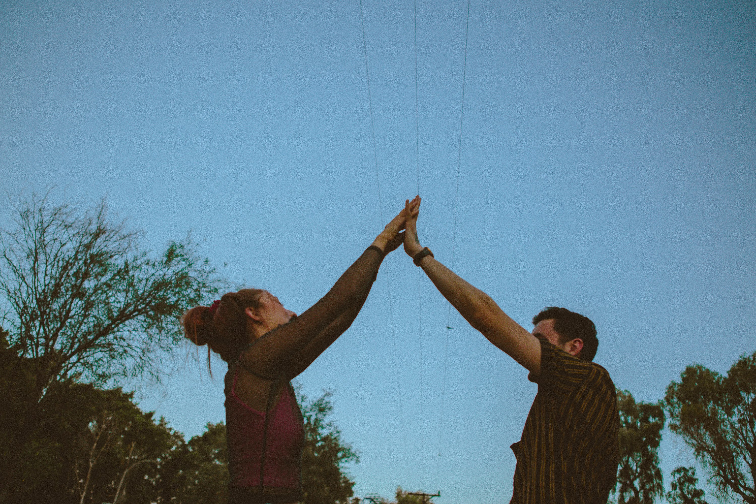 man in brown shirt holding womans hand