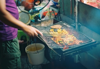 A chef preparing fresh kabobs on a grill.