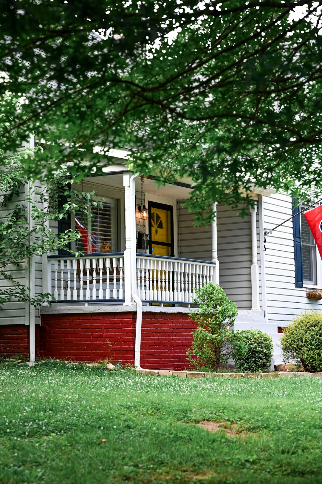 white and red wooden house near green trees during daytime