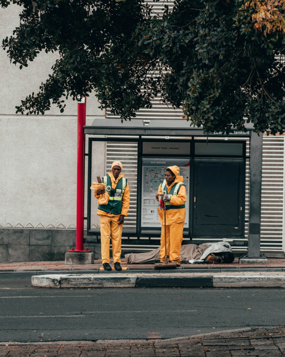 man and woman standing beside red and white post