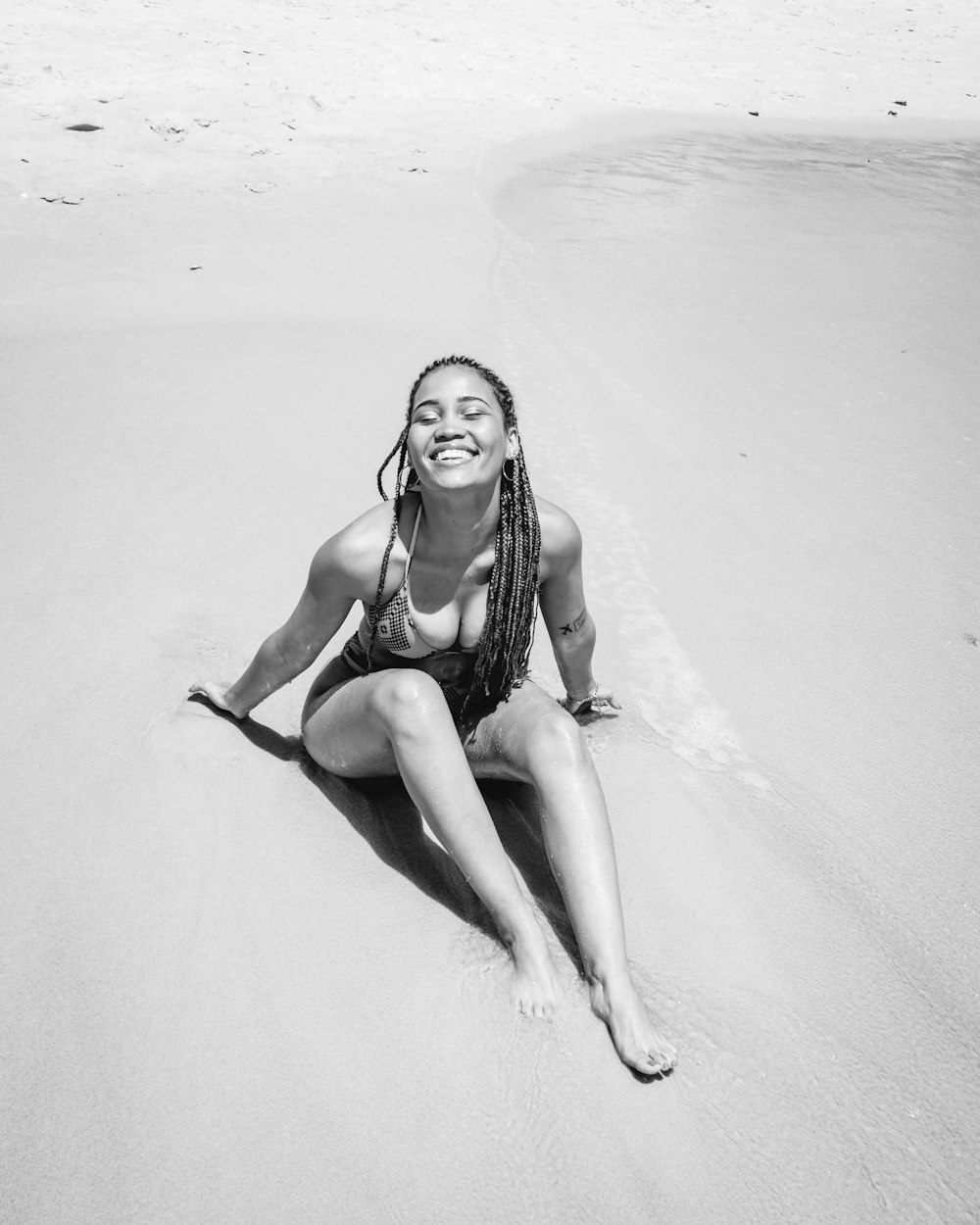 donna in bikini seduta sulla spiaggia
